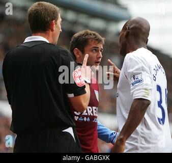 Shaun Maloney (c) di Aston Villa e Luis Boa morte di West Ham United non sono d'accordo a seguito di una recente sfida. L'arbitro Steve Tanner guarda sopra Foto Stock