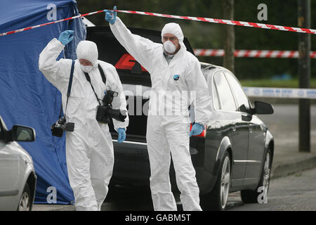 Ufficiali di Forensics assistono alla scena di una sparatoria mortale la notte scorsa di un uomo, al Casement Park a Finglas, a nord di Dublino. Foto Stock