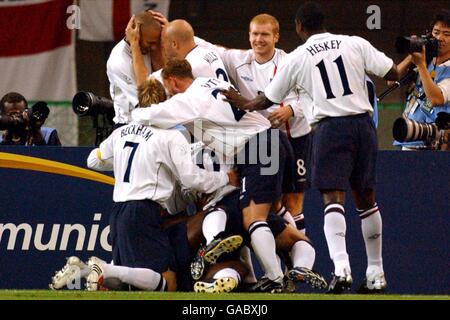 Calcio - Coppa del mondo FIFA 2002 - secondo turno - Danimarca / Inghilterra. Il Rio Ferdinand d'Inghilterra celebra l'apertura del punteggio con i compagni di squadra Foto Stock