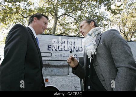 Il leader del Partito conservatore David Cameron parla con l'ex rugby inglese Matt Dawson dopo aver firmato l'autobus 'Good Luck England' nel centro di Londra prima di partire per la finale della Coppa del mondo di Rugby a Parigi. Foto Stock