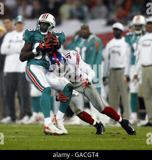Il giocatore dei Delfini di Miami Marty Booker viene affrontato dal giocatore dei New York Giants Aaron Ross durante la partita NFC Eastern Division a Wembley, Londra. Foto Stock