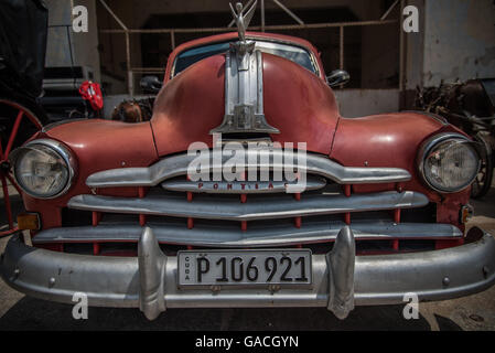 Vivace colore rosso brillante splendidamente weathered classic American automobile disponibile per un tour della città intorno a La Habana, Havana, Cuba. Foto Stock