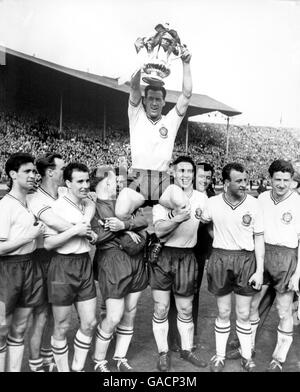 Il capitano vincitore, Nat Lofthouse di Bolton Wanderers, tiene la fa Cup Aloft mentre i suoi compagni lo sostengono Foto Stock