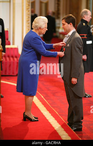 Il sig. Dominic Meiklejohn è fatto un OBE dalla regina a Buckingham Palace. Foto Stock