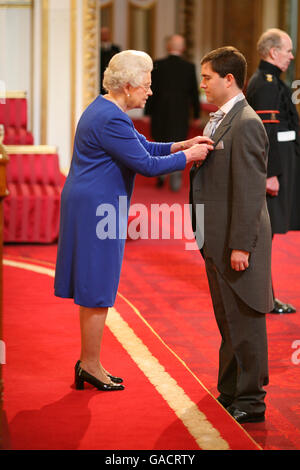 Il sig. Dominic Meiklejohn è fatto un OBE dalla regina a Buckingham Palace. Foto Stock