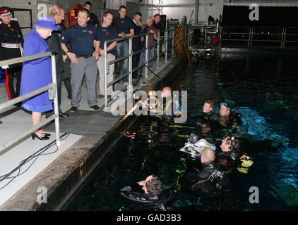 La regina Elisabetta II della Gran Bretagna, a sinistra, incontra i subacquei che lavorano sul palcoscenico sottomarino ai Pinewood Studios, Inghilterra. Foto Stock