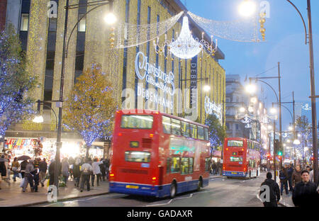 Il negozio Debenhams di Oxford Street, Londra, saluta i primi acquirenti di Natale con una mostra di luci mentre passeggano nella speranza di trovare quel dono elusivo. Foto Stock