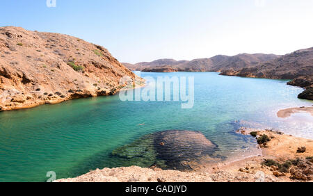 Panorama di un simile a un fiordo di Bandar Khayran con un blu verde acqua e una spiaggia rocciosa, il sultanato di Oman, situata ad un ora di auto di Muscat Foto Stock