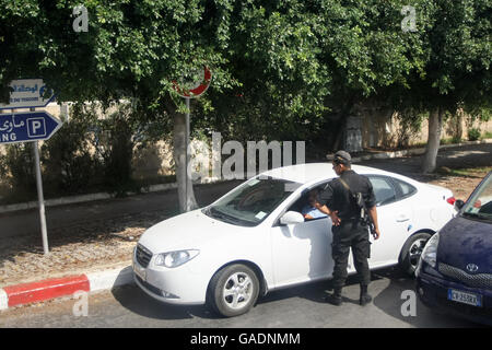 Un poliziotto la verifica di un driver nella macchina parcheggiata sul lato della strada dal porto di Port El Kantaoui, a Sousse, Tunisia. Foto Stock