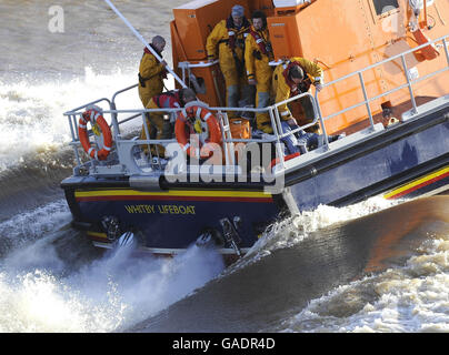 L'equipaggio di Whitby Lifeboat torna dopo aver salvato l'equipaggio di una piccola barca che affondava oggi in acque difficili fuori Whitby Harbour. Foto Stock