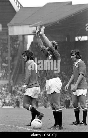 Bobby Charlton (c) del Manchester United segnala i suoi progressi mentre si prepara a prendere un calcio di punizione, guardato dai compagni di squadra George Best (l) e Ian Story-Moore (r) Foto Stock