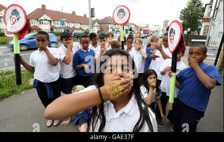 È sotto embargo per 0001 Martedì 5 luglio cenere (nessun cognome dato), un allievo di Bowes scuola primaria a Enfield, a nord di Londra, copre la sua bocca come alunni della scuola prendere parte alla ClientEarth 'say n. di aria sporca campagna" al di fuori della loro scuola, la quale è adiacente alla North Circular ring road. Foto Stock