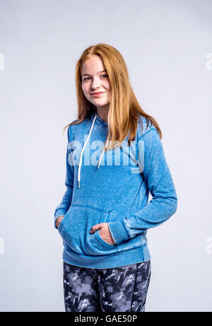 Ragazza in felpa blu e gambali fitness, studio shot Foto Stock