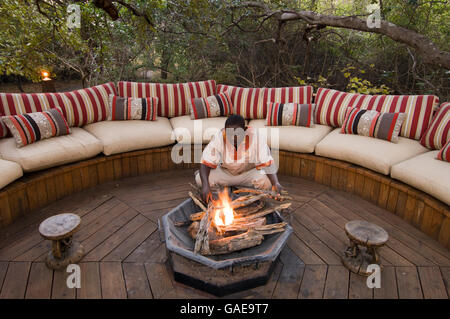 L'uomo messa a fuoco nella parte anteriore del lounge, Kapinga Camp, Busanga Plains, Parco Nazionale di Kafue, Zambia, Africa Foto Stock