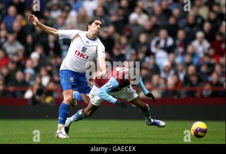 Miguel Pedro Mendes di Portsmouth e Ashley Young di Aston Villa (a destra) Foto Stock