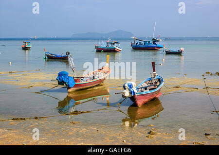 Coda lunga imbarcazioni a bassa marea a Rawai Beach a Phuket Thailandia meridionale Foto Stock