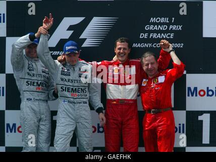 Michael Schumacher della Ferrari festeggia in cima al podio Con Jean Todt dopo aver vinto il suo quinto Campionato del mondo driver.McLaren's. David Coulthard solleva il braccio del compagno di squadra Kimi Raikkonen dopo che è arrivato molto vicino a vincere la gara Foto Stock