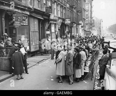 Gli elettori schierate tre il passo sul marciapiede al di fuori delle elezioni generali in luogo di polling a 112Street e Fifth Avenue. La linea si estende quasi un blocco. Foto Stock