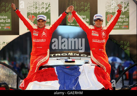 Sebastien Loeb (a destra) della Francia e il suo co-pilota Daniel Elena riconoscono la folla dopo aver concluso terzo nella Citroen C4 WRC del Wales Rally GB per clackinch il Campionato del mondo Rally. Foto Stock