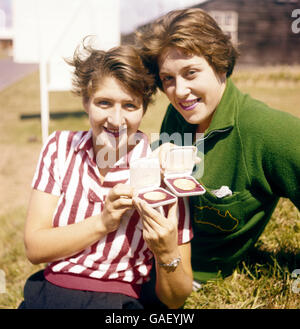 1958 British Empire and Commonwealth Games - nuoto - Cardiff. Australia's Dawn Fraser (l) con il collega nuotatore australiano Sandra Morgan mostra le medaglie ha vinto il primo giorno di nuoto eventi Foto Stock