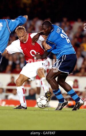 Dennis Bergkamp (l) dell'Arsenal tiene fuori la sfida di Manchester Marc-Vivien Foe della città Foto Stock