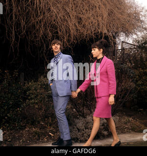 Passeggiando a mano in mano sono Ringo Starr, il batterista dei Beatles, e la sua sposa, l'ex Maureen Cox. Sono raffigurati nel giardino della casa a Princes Crescent, Hove, Sussex, prestati dal solicitor David Jacobs per una breve luna di miele. La coppia è stata sposata in una cerimonia di primo mattino presso l'ufficio di registrazione di Caxton Hall, Londra. Foto Stock