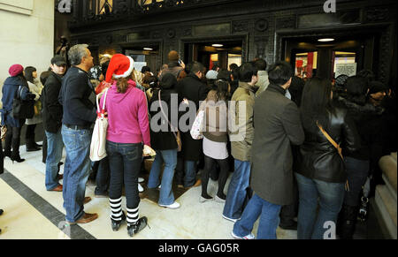 I clienti si fanno strada attraverso le porte del negozio Oxford Street di Selfridge nel centro di Londra, dove la loro vendita di Natale inizia questa mattina. Foto Stock