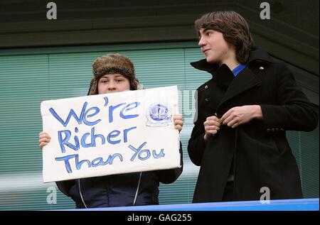 Un fan dei Queen's Park Rangers tiene un cartello verso i fan in viaggio del Chelsea, negli stand prima del gioco. Foto Stock