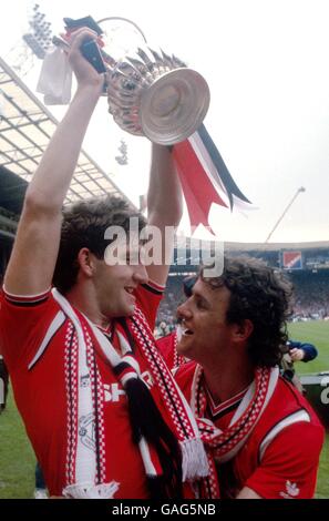 Kevin Moran (r) di Manchester United guarda Norman Whiteside alzarsi La tazza fa in festa Foto Stock