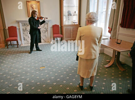 La Regina Elisabetta II della Gran Bretagna ascolta lo studente di violino post-categoria Giovanni Guzzo suonare un violino Stradivari, come parte della sua visita alla Royal Academy of Music nel centro di Londra. Foto Stock