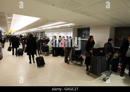 I passeggeri in coda al Terminal 1 dell'aeroporto di Heathrow dopo la nebbia fitta hanno causato numerose cancellazioni di voli. Foto Stock
