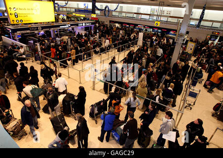 I passeggeri in coda al Terminal 1 dell'aeroporto di Heathrow dopo la nebbia fitta hanno causato numerose cancellazioni di voli. Foto Stock