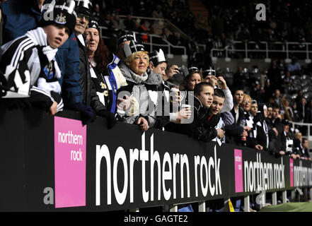 I fan di Newcastle United si siedono dietro le tavole pubblicitarie di Northern Rock al St James Park questa sera. Foto Stock