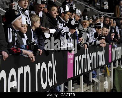 I fan di Newcastle United si siedono dietro le tavole pubblicitarie di Northern Rock al St James Park questa sera. Foto Stock