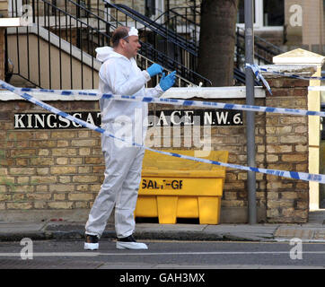Un ufficiale di polizia forense assiste la scena a Kilburn, a nord di Londra, dopo la scoperta di un corpo avvolto in fogli. Foto Stock