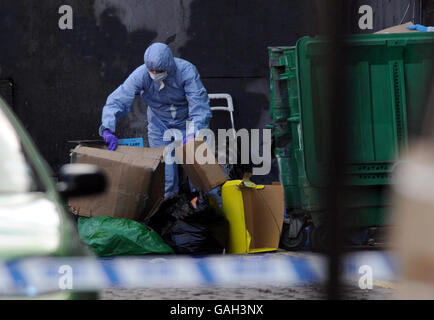 Un ufficiale di polizia forense assiste la scena a Kilburn, a nord di Londra, dopo la scoperta di un corpo avvolto in fogli. Foto Stock