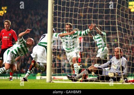 Henrik Larsson di Celtic celebra (al centro) il loro obiettivo vincente mentre Chris Sutton e John Hartson si affrettano a congratularsi con lui, il portiere di Blackburn Rovers Brad Friedel si siede abbattuto Foto Stock