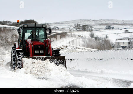 Un agricoltore locale lavora per sgombrare la strada per la sua azienda agricola appena fuori dalla A66 trans-pennine strada in Cumbria a causa della caduta di neve che ha portato alla chiusura della strada. Foto Stock