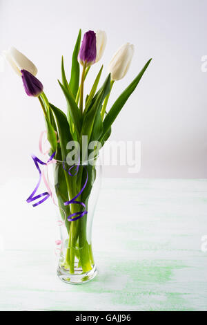 Bouquet di bianco fresco tulipani in un vaso verticale. Cornice di fiori. Sfondo di fiori. Bouquet di fiori. Biglietto di auguri. La festa della mamma. P Foto Stock