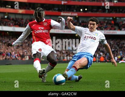 Il Bacary Sagna dell'Arsenal (l) e Gareth Barry (r) dell'Aston Villa combattono per la palla durante la partita della Barclays Premier League all'Emirates Stadium di Londra. Foto Stock