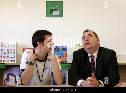 Il primo ministro scozzese Alex Salmond parla a Jonathan, allievo della New Struan School, che è un centro specializzato per l'autismo, ad Alloa, nella Scozia centrale. Foto Stock