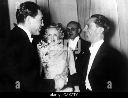 L'ex campione del mondo dei pesi massimi Max Schmeling (l) scrolla le mani con il ministro nazista della Propaganda Joseph Goebbels (r) in un ricevimento lanciato dal dottor Goebbels a Berlino in occasione del Motor Show tedesco. Guardando sopra è la moglie dell'attrice di Schmeling, Anny Ondra (c) Foto Stock