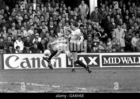 (L-R) Frank McAvennie, di West Ham United, spara in una croce Come Oxford United's Malcolm Shotton cerca di bloccare Foto Stock