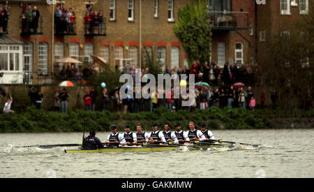 Gli spettatori guardano avanti a Oxford mentre si avvicinano al traguardo davanti a Cambridge durante la Boat Race sul Tamigi a Londra. Foto Stock