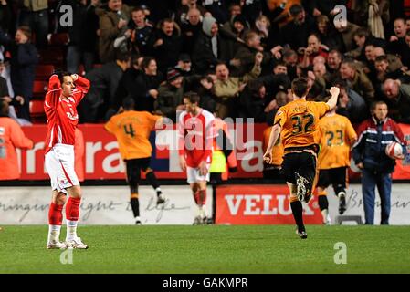 Il Lee Cook di Charlton Athletic (a sinistra) sembra sfidato mentre i giocatori di Wolverhampton Wanderers celebrano il punteggio del gol vincente in ritardo nel gioco. Foto Stock