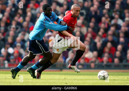 Mikael Silvestre (r) di Manchester United cerca di allontanarsi Marc Vivien Foe di Manchester (l) Foto Stock