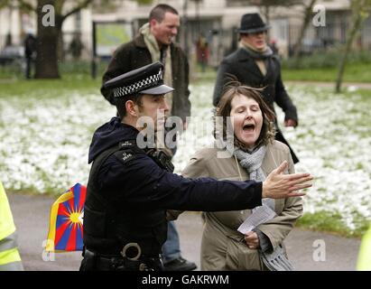 I dimostranti protestano mentre la torcia si avvicina a North Carridge Drive durante il relè della torcia delle Olimpiadi di Pechino a Londra. Foto Stock