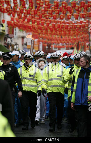 L'ambasciatore cinese nel Regno Unito fu Ying trasporta la torcia olimpica attraverso la Chinatown di Londra durante una parte del suo viaggio attraverso Londra sulla relativa strada all'illuminazione del cavoldron olimpico all'Arena O2 a Greenwich. Foto Stock