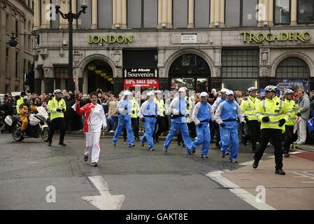 La torcia passa il Trocadero su Coventry Street durante il Relè della torcia per le Olimpiadi di Pechino a Londra Foto Stock