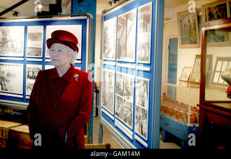La regina Elisabetta II guarda le mostre nel museo Tate & Lyle durante una visita alla raffineria di zucchero Tate & Lyle di Londra est, che celebra 130 anni di produzione. Foto Stock
